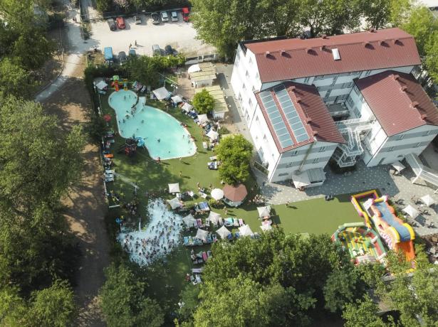 Vista aerea di una piscina affollata accanto a un edificio.